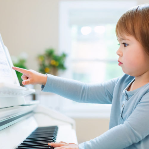 Toddler girl playing piano