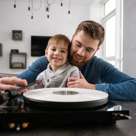 man and boy in front of record player